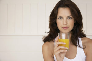 woman-holding-a-glass-of-orange-juice-and-looking-skeptical